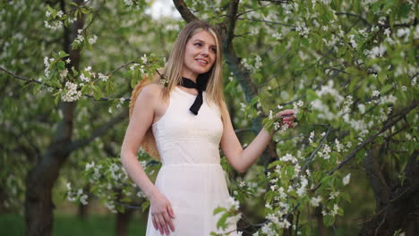 Retrato-De-Una-Joven-Encantadora-En-Un-Jardín-Floreciente-Una-Dama-Atractiva-Está-Parada-Debajo-De-Un-árbol-Frutal