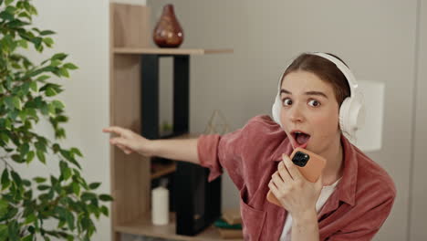 woman singing and dancing with headphones to mobile phone