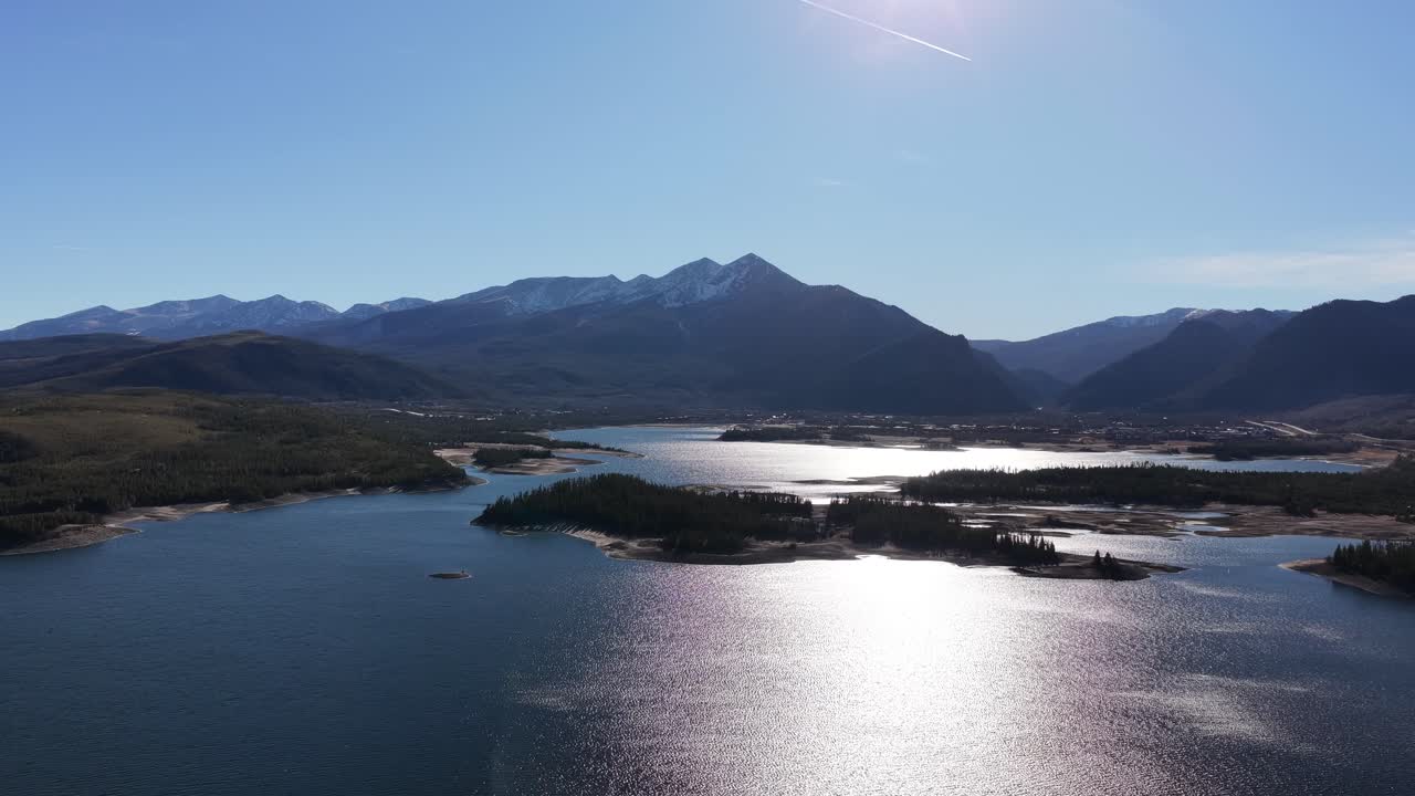 Ascending, curling drone shot of Dillon Reservoir looking towards towards Frisco, Colorado in the Rocky Mountains