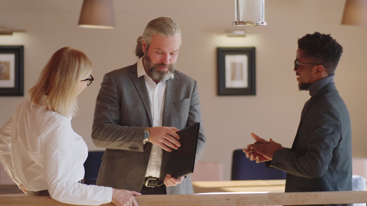 Multiethnic Business Partners Discussing Contract in Restaurant