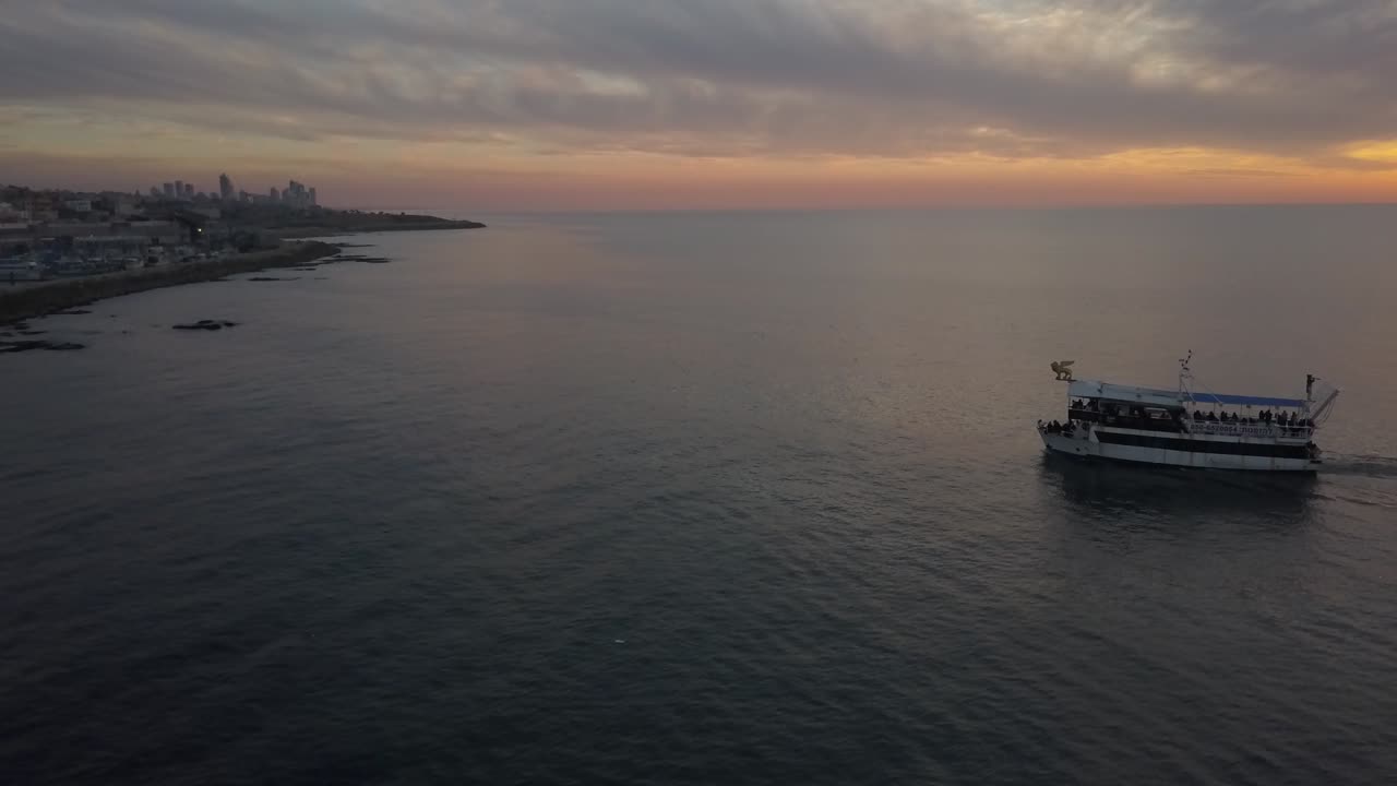 barco en el mar, cerca de la ciudad de tel aviv, israel durante la puesta del sol.