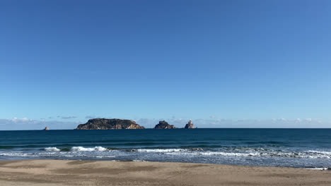 Hermosa-Foto-De-Una-Playa-Mágica-Y-Solitaria-En-Málaga,-España-Durante-El-Día-Con-Olas-Golpeando-Las-Costas-Con-Un-Poderoso-Color-Azul