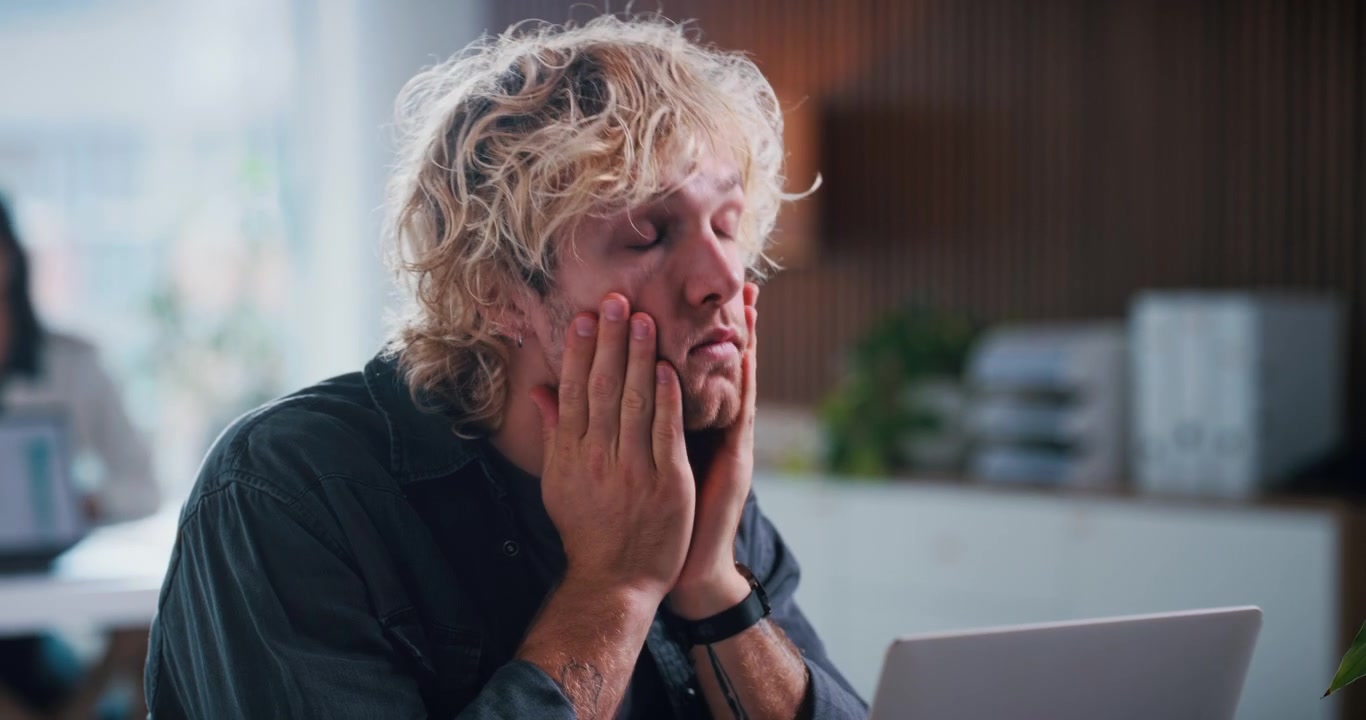 Stressed Young Man Working on Laptop in Office