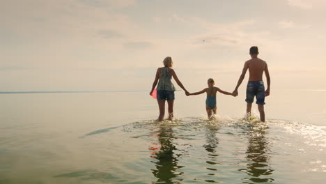 Mother-And-Childrens-Walking-On-The-Shallow-Water-At-Sunset
