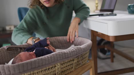 Video-Einer-Kaukasischen-Mutter,-Die-Von-Zu-Hause-Aus-Mit-Ihrem-Neugeborenen-Am-Laptop-Arbeitet