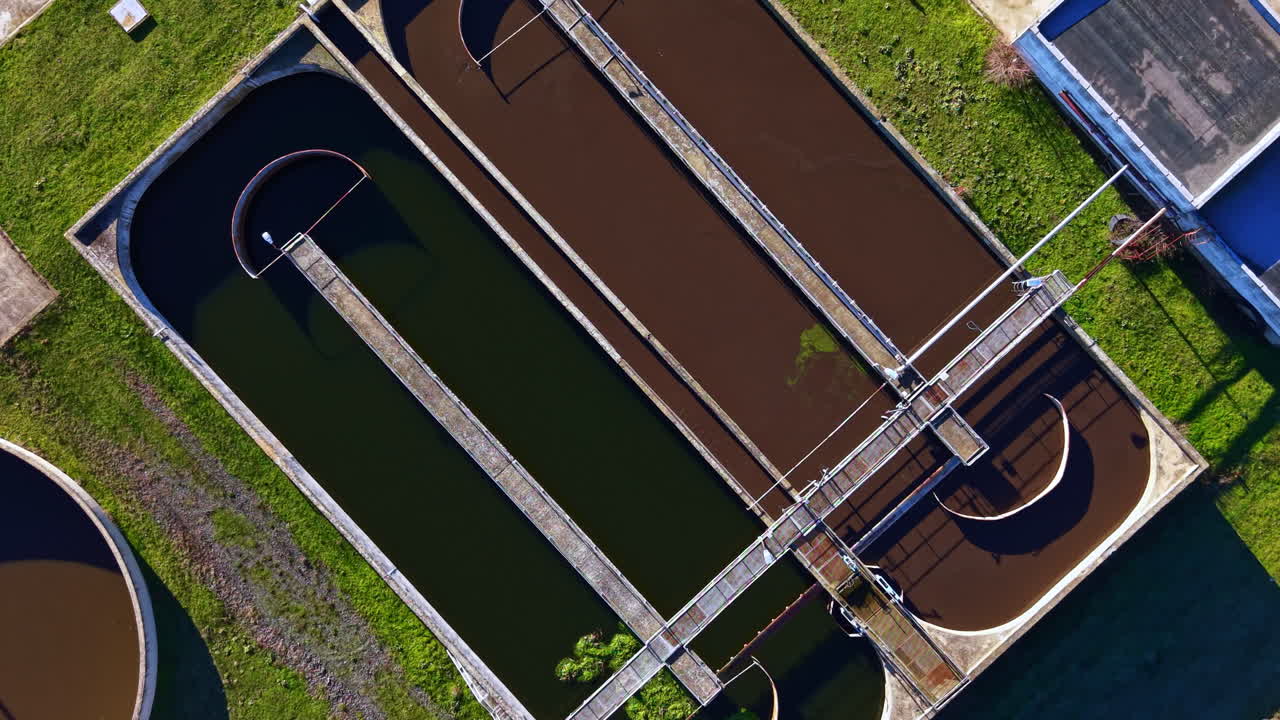 Water treatment facility showing multiple tanks for wastewater processing at a municipal location during daylight hours