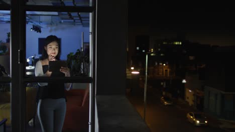 Video-of-asian-woman-with-tablet-working-late-in-office