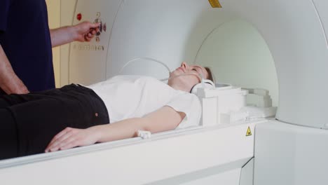 mujer sometida a una resonancia magnética con el médico presente