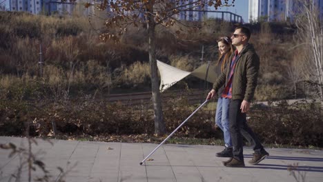 blind man walking in the park with his wife in autumn.