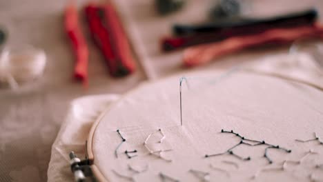 embroidery hoop with white fabric and needle