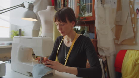 seamstress using sewing machine in atelier