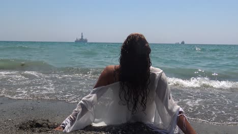 a beautiful woman lounges in the waves at a tropical beach