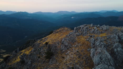 Die-Drohne-Zieht-über-Einen-Grauen-Steingipfel-Im-Pico-De-Los-Reales-In-Estepona,-Spanien,-Zurück