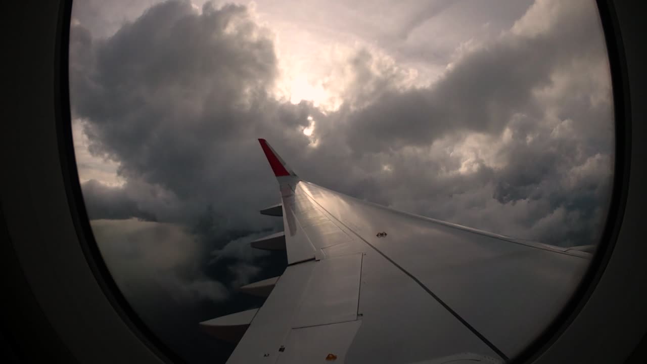 puesta de sol y hermosas nubes desde la ventana del ala izquierda del avión trae recuerdos de viaje