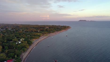Aerial-view-of-a-sandy-beach-and-sea-in-Negros-Oriental,-Philippines,-at-sunset