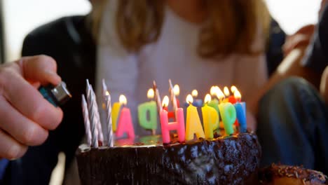 close-up of grandfather lighting candles on birthday cake 4k