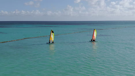 Dos-Pequeños-Catamaranes-Navegan-En-El-Mar-Caribeño-Turquesa,-Diversión-En-Deportes-Acuáticos-Y-Recreación-En-Un-Paraíso-Tropical