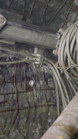 machinery equipment drills holes for setting explosives in ore mine. professional robot drill with coolant operates to mine minerals closeup