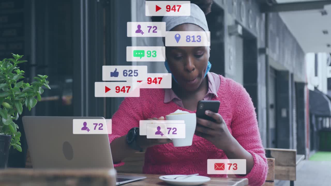 animación de notificaciones de redes sociales sobre mujer afroamericana usando teléfono inteligente en una cafetería