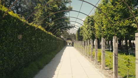 gardens of schloss mirabell in salzburg, with statues, manicured hedges, and tourists enjoying the scenery on a sunny day