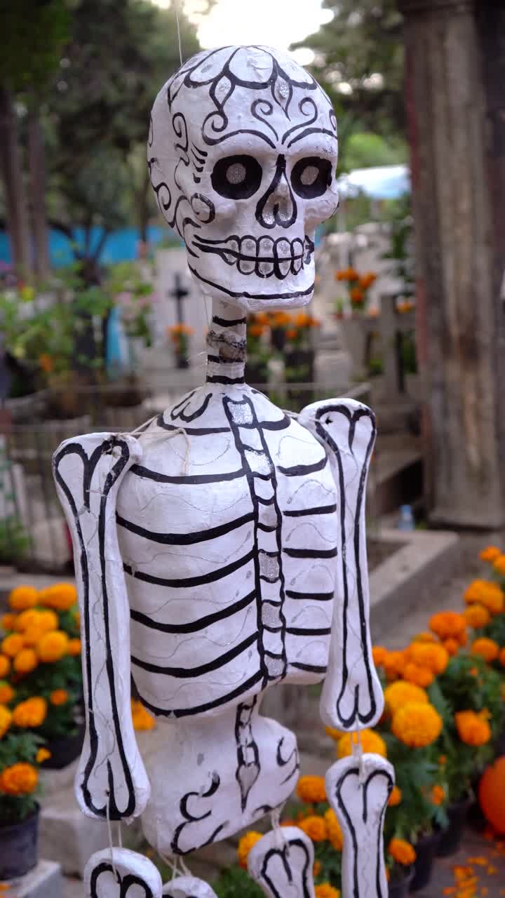 Scheletri di carta in un cimitero per le celebrazioni del festival del Giorno dei Morti