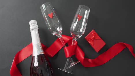 champagne glasses and bottle with present and red ribbon at valentine's day