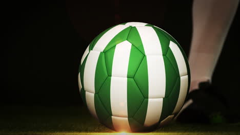 football player kicking nigeria flag ball