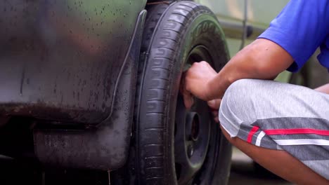 Slow-motion---Close-up-shot-of-a-man-is-removing-wheel-from-the-car