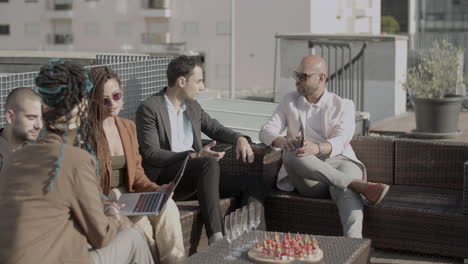 side view of group of coworkers hanging out in outdoor cafe