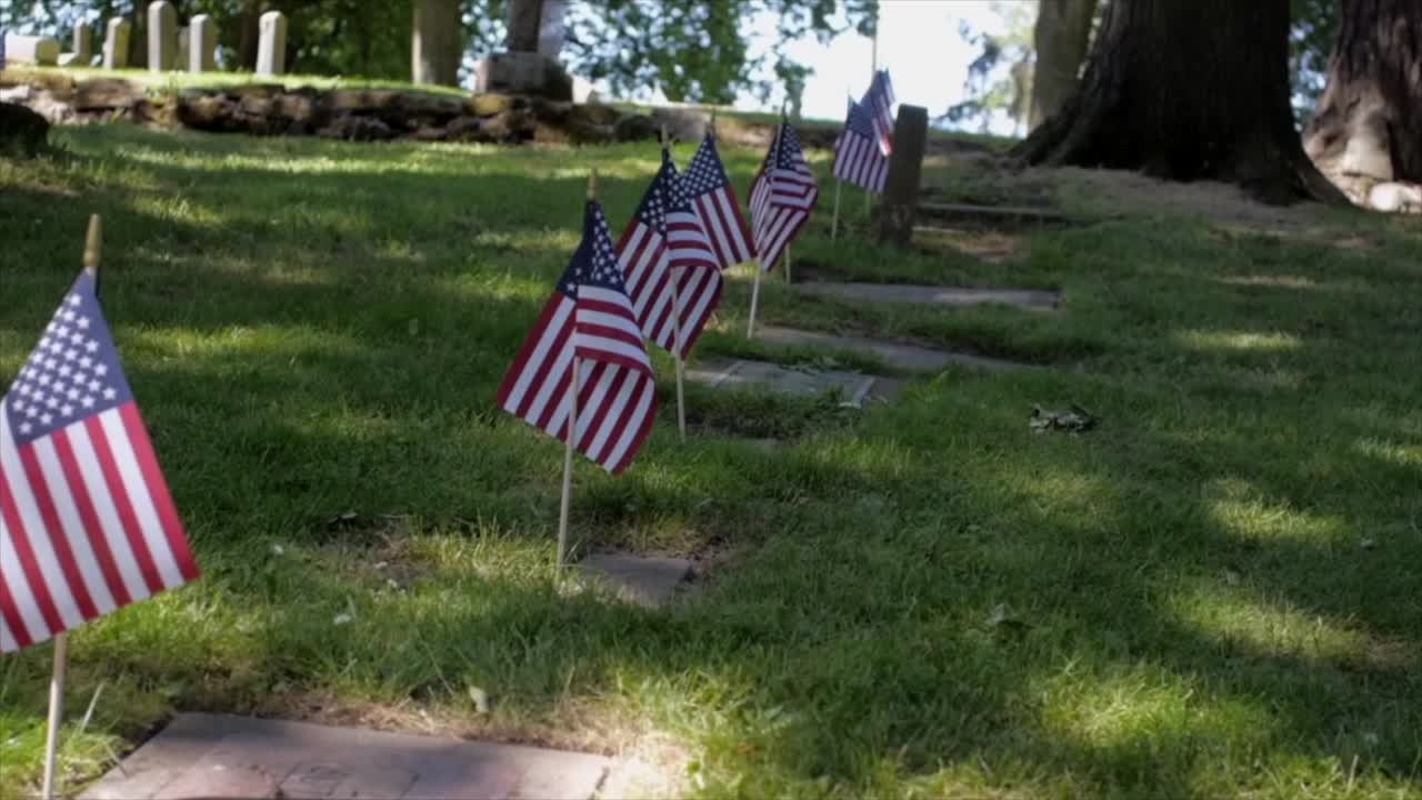 Mini American flags on military headstones for memorial day.