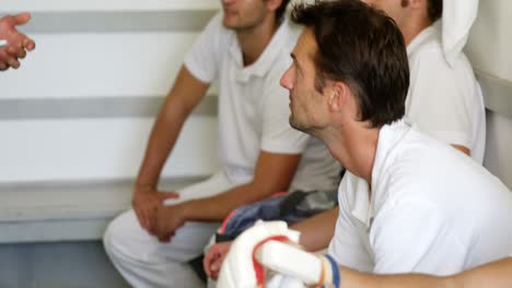 coach interacting with cricket players