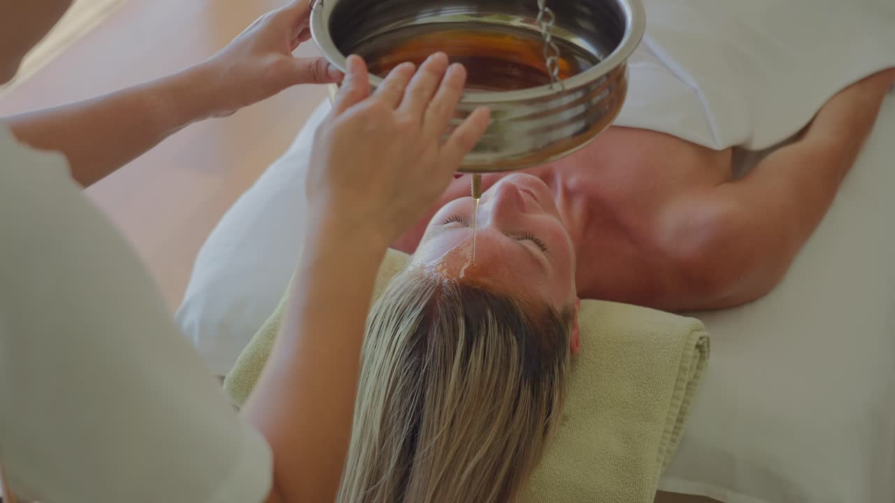 시로다라 치료, 여성의 이마에 약용 기름을 천천히 떨어뜨리는 것