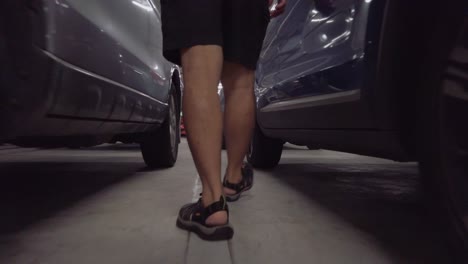 pov to man's feet while walking in parking lot and get into car in slowmotion