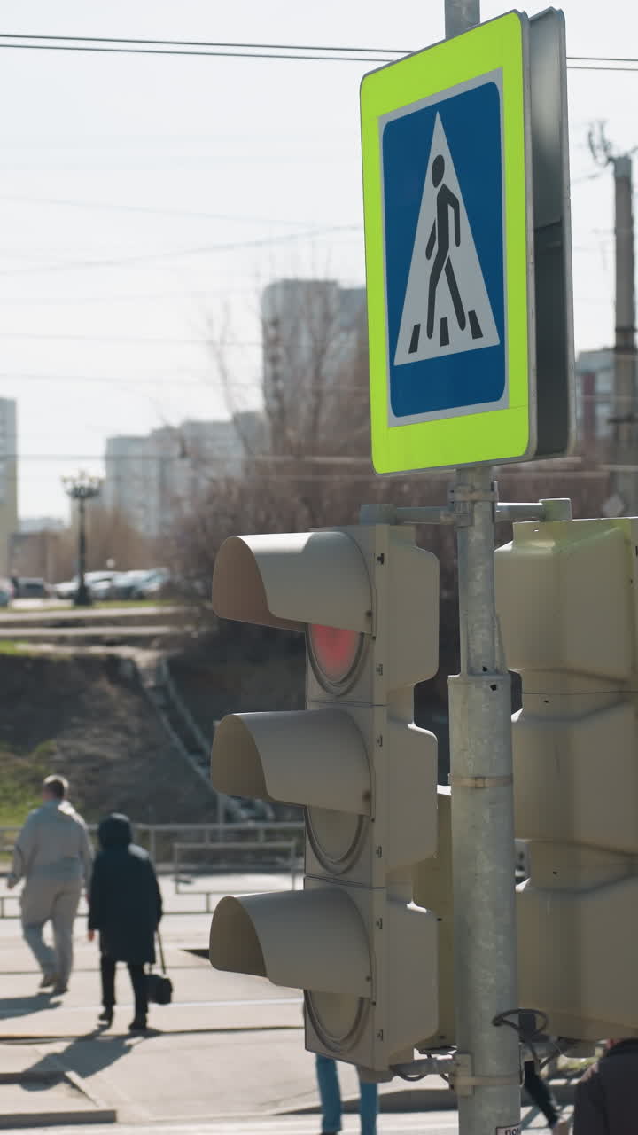 vista cercana de un cruce peatonal ocupado de la ciudad con peatones y un semáforo, con individuos cruzando la calle