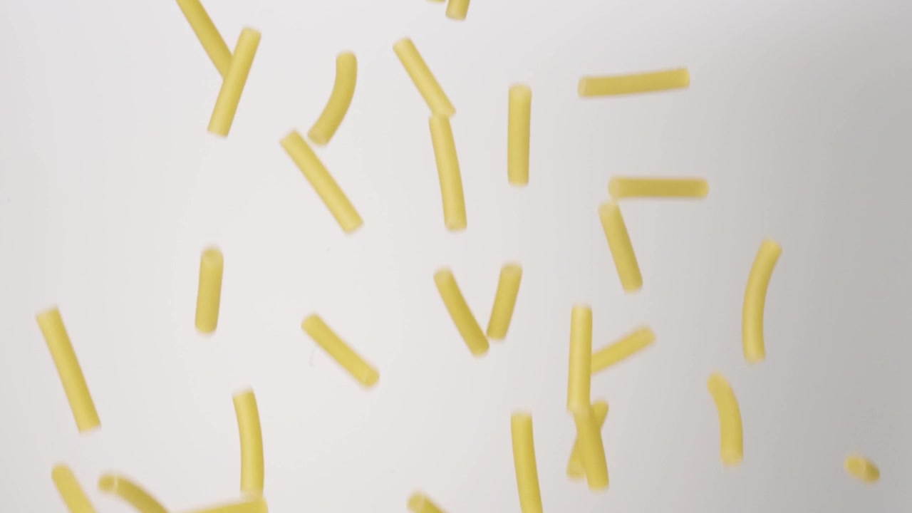 Ziti e cannelloni freschi non cotti che cadono su uno sfondo bianco in slow motion, primo piano macro