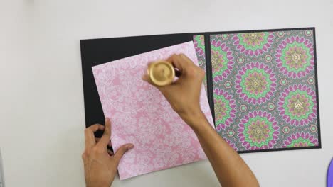 Gluing-binder-scrapbook-cover-with-papers-with-mandala-decorations