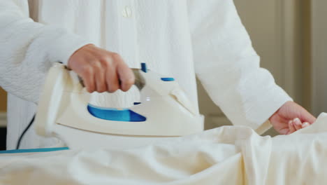 mujer planchando una camisa blanca