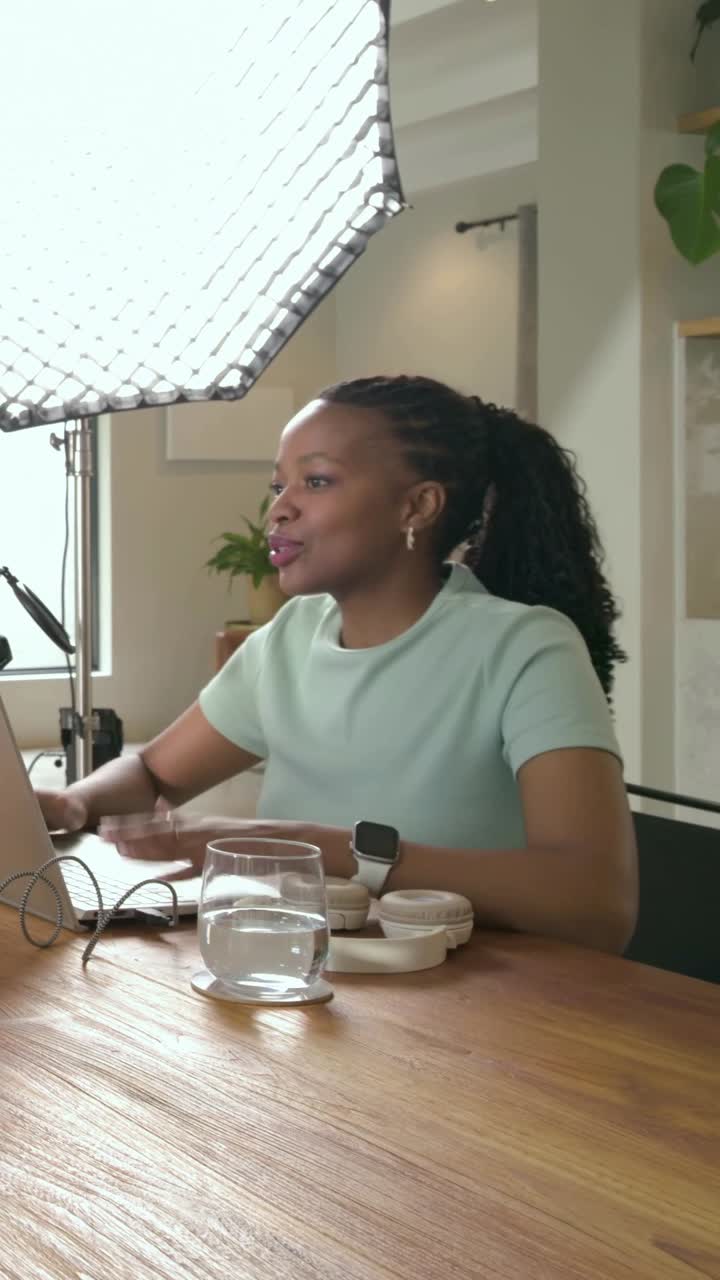Vertical video: Noticing hand entering, typing woman shaking hand, leaning into laptop in studio