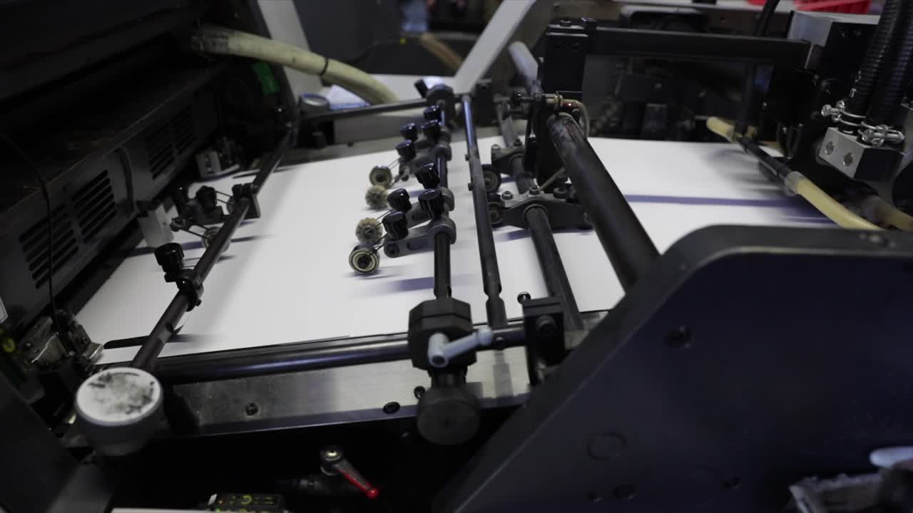 Industrial printer uploads paper, close up view