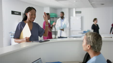 diverse female doctors discussing work at reception desk at hospital, slow motion