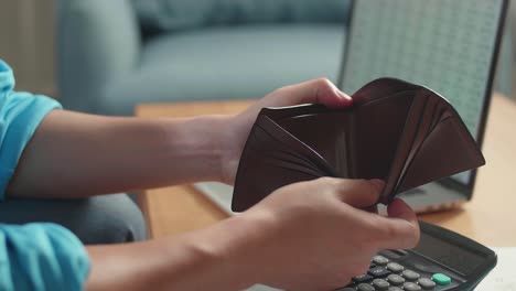 close up of man's hand holding and opening the wallet to check money