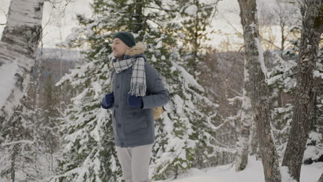 hombre caminando en un bosque nevado