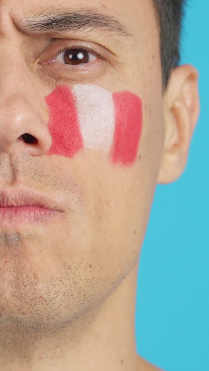 Serious man with a peruvian flag painted on the face
