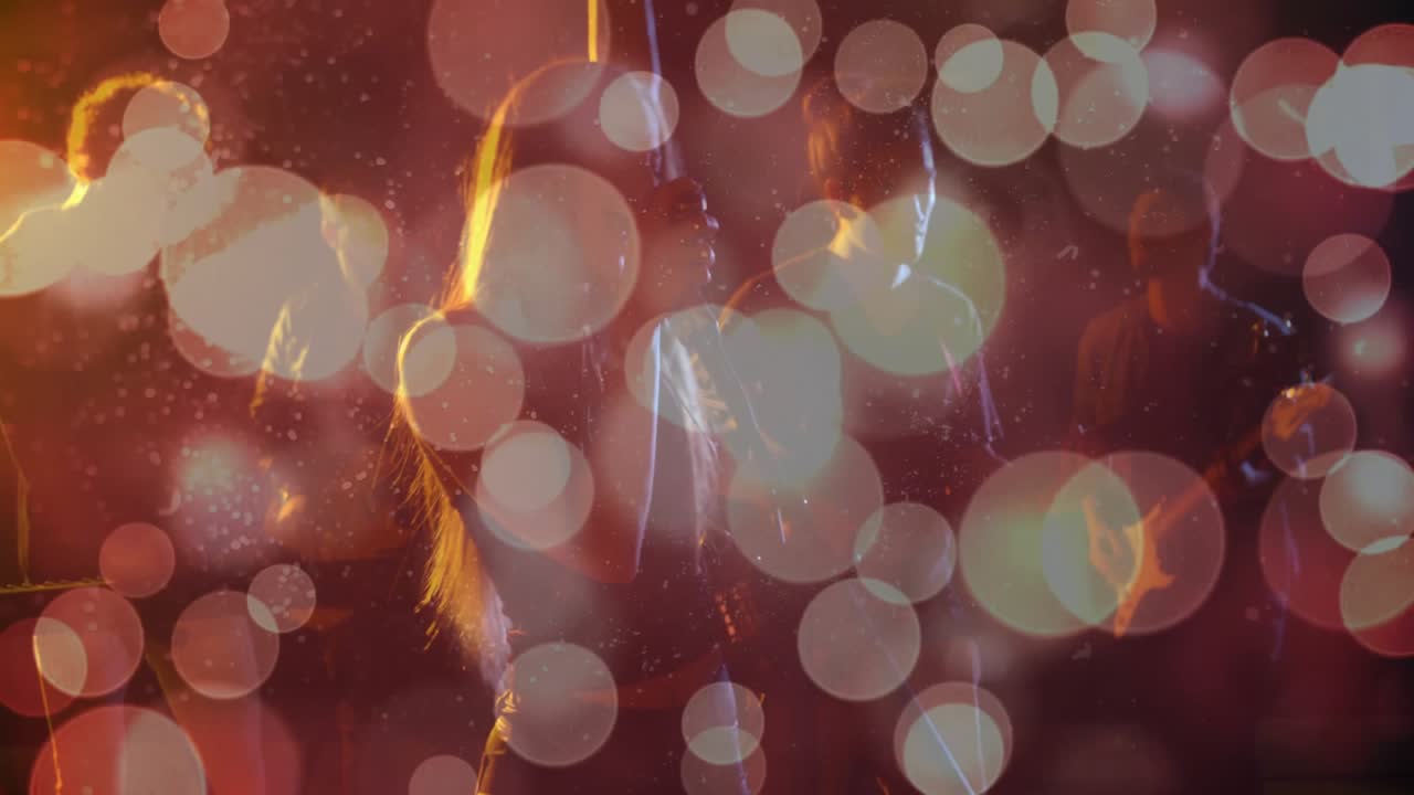 Guitarist træder ind på scenen under rød-orange scenelys med pulserende bokeh, mens han fremfører guitarsolo