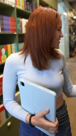 young woman in a bookstore with a tablet