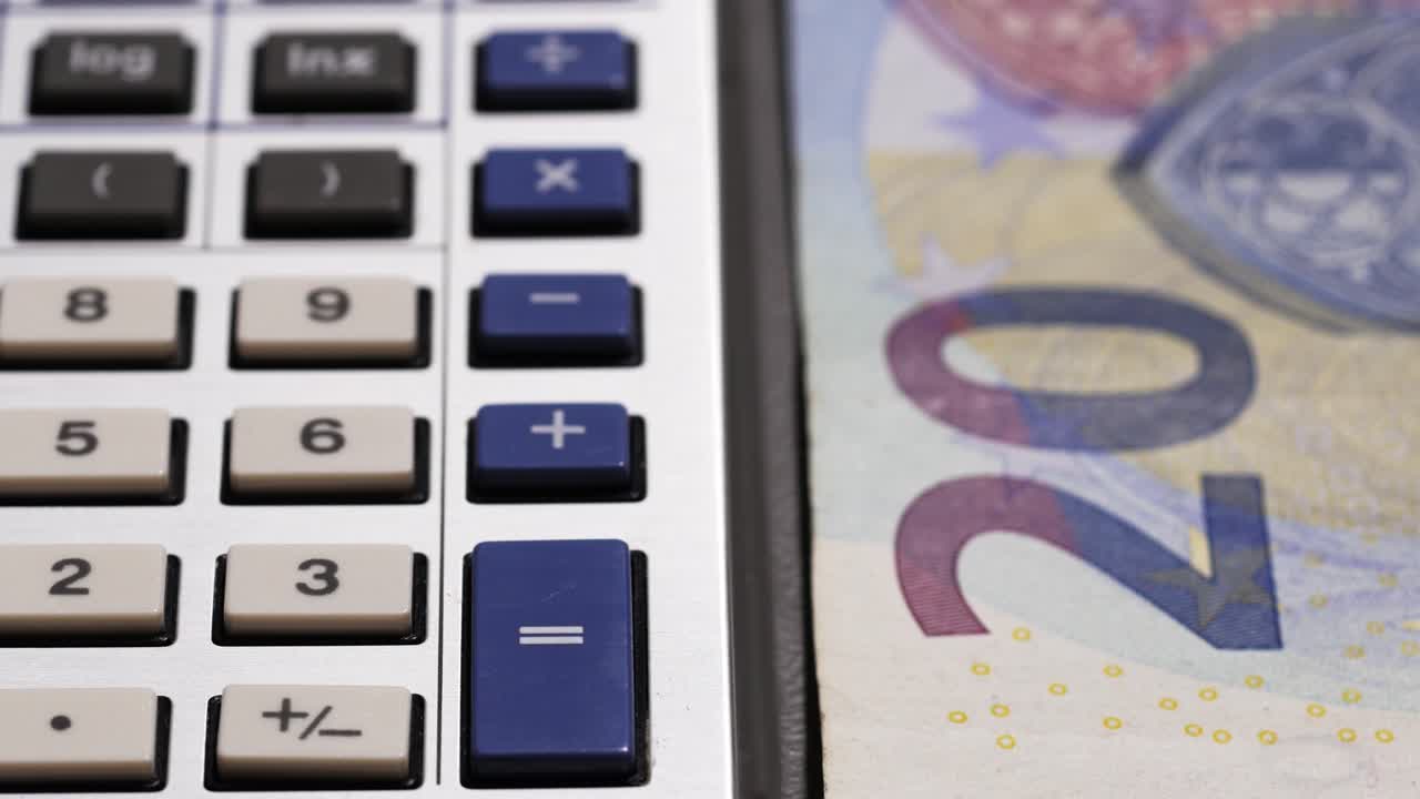 Conteggio di banconote da 20 euro accanto a una calcolatrice blu e grigia