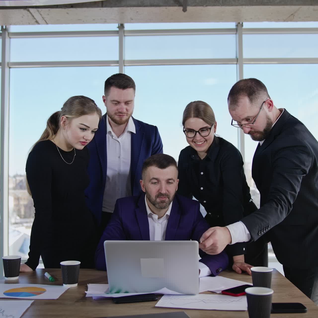 Professional business team creating ideas and making suggestions. Cooperative teamwork discuss ideas in front of laptop. Big office windows at the backdrop