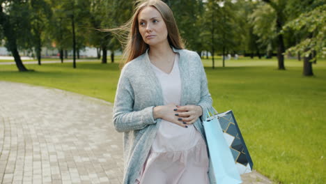 pregnant woman experiencing discomfort while shopping in a park
