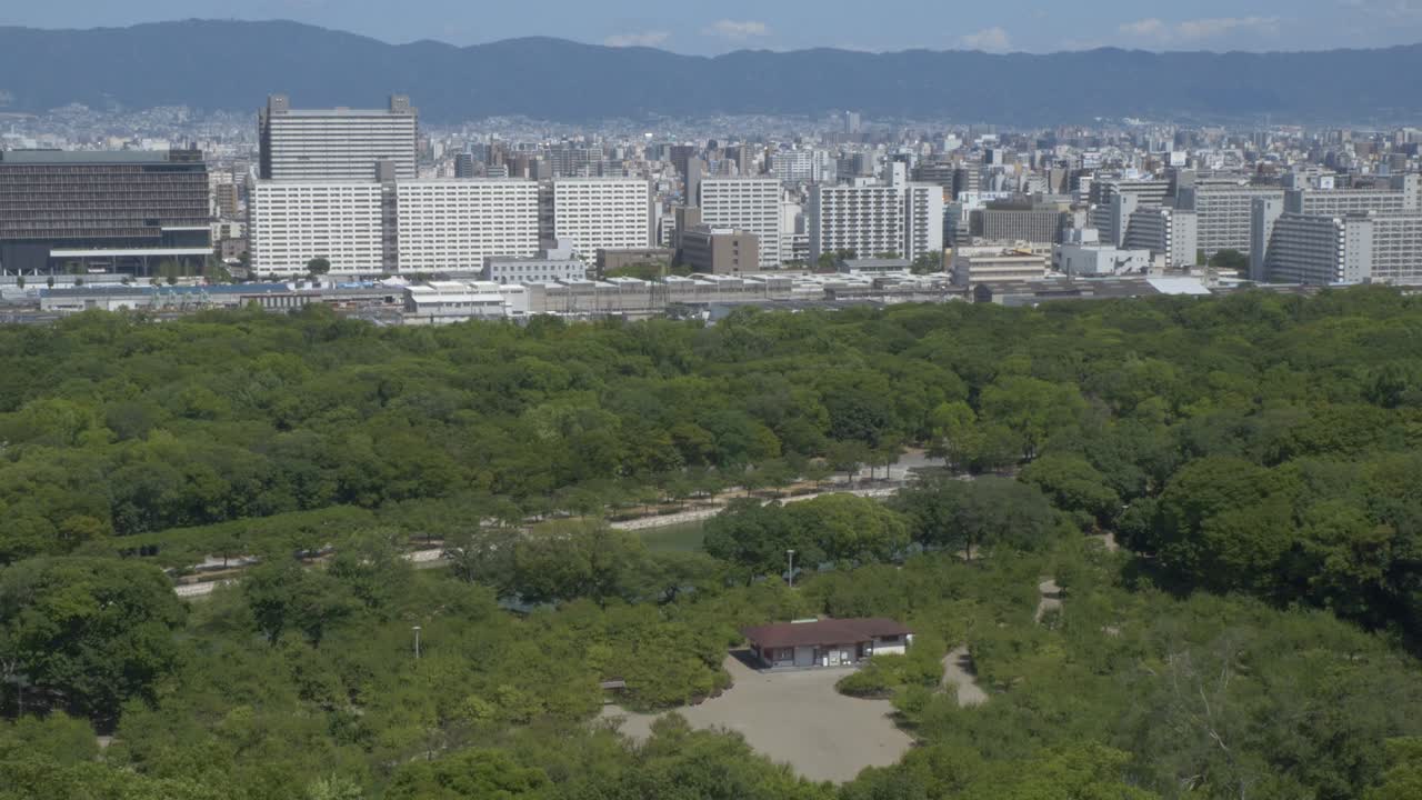 Lush Nature Of Nishinomaru Garden With Urban Landscape In The Background In Osaka, Japan. Wide Shot