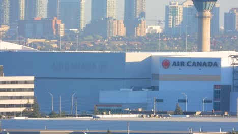 airplane taking off from a toronto runway with city skyscrapers in the background, aviation departure